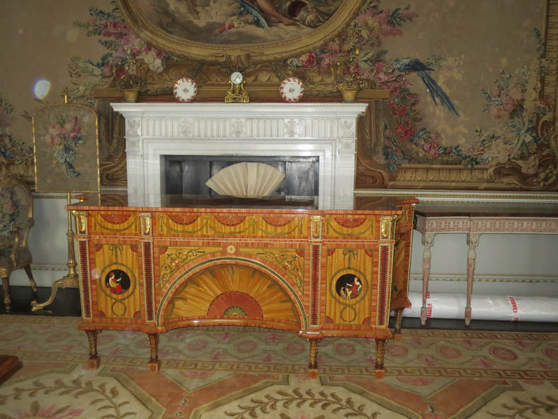 The top is so highly polished that the mantlepiece appears to come out of the commode.